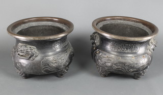 A pair of 19th Century Japanese bronze twin handled jardinieres, raised on 3 mask supports 13"h x 16" diam. 