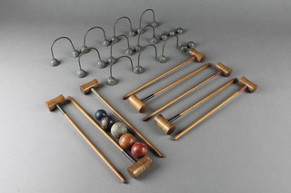 A Victorian table top croquet game comprising 8 mallets, 10 hoops, 4 green coloured balls and 1 further ball, 2 lead hoop supports