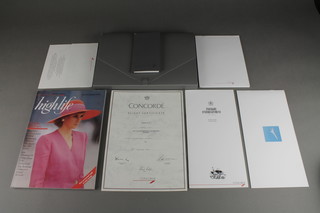 A gray plastic folder containing a Concorde flight certificate dated 1990, a September 1990 edition of Highlife Magazine, a Concorde diary, brochure, guide to inflight entertainment, menu, letter head