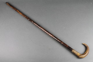 A bamboo cane with embossed gilt metal band and horn handle 