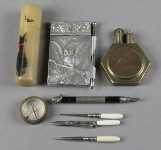 A First World War brass trench art lighter decorated a 1918 penny, a circular compass 1", a bodkin, a hook and a pair of scissors contained in a horn case decorated a cat, an aluminium aide memoir decorated an owl the eyes set hardstone (1 missing) etc 