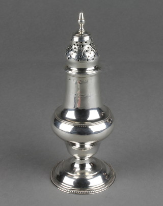 A George III silver shaker of baluster form with engraved inscription and crest 6" 100 grams 