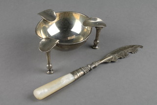A silver ashtray on raised feet, Birmingham 1925 together with a silver bladed butter knife
