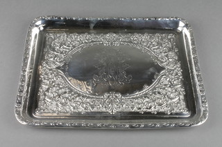 An Edwardian repousse silver dressing table tray with floral and scroll decoration, the cartouche with monogram, Walker & Hall Sheffield 1905, 10", 300 grams