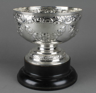 A good Edwardian repousse silver punch bowl with scroll and floral decoration and waisted stem, Birmingham 1906, 10", 1030 grams, on a wooden socle 