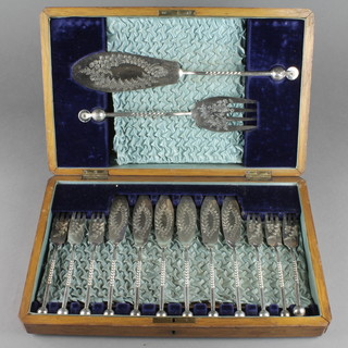 An Edwardian oak canteen containing a set of silver plated fish eaters for 6 with spiral handles and servers 