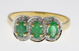 A 14ct yellow gold emerald and diamond triple cluster ring, size M