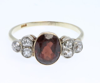 An 18ct gold garnet and diamond 7 stone ring, size Q 1/2