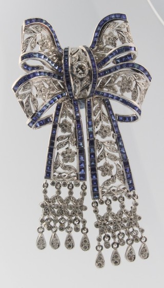 A fine 18ct white gold diamond and sapphire open ribbon brooch with diamond tassels 