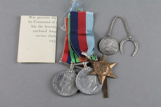 A trio of medals with posting box 1939-45 Star, British War and Victory medal and 8th Army lucky charm 