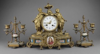 A 19th Century French 8 day striking mantel clock with enamelled dial and Roman numerals contained in a gilt spelter case, with porcelain plaques to the base supported by 2 classical figures, together with a pair of associated twin light candelabrum