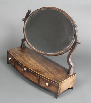 A Georgian oval bevelled plate dressing table mirror contained in a mahogany swing frame and raised on a bow front base fitted 1 long drawer flanked by 2 small drawers with ivory handles and bracket feet 22"h x 24 1/2"w x 9" d