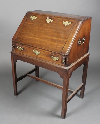 A Georgian mahogany bureau on stand, the fall front revealing a well fitted interior with pigeon holes, drawers and a well, the fall having 3 locks and brass drop handles to the side, fitted a drawer, raised on a stand with square tapering supports and H framed stretcher 36"h x 26"w x 17 1/2"d 