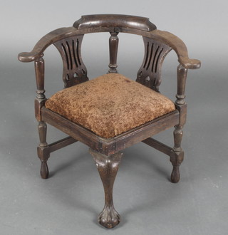 A Georgian style childs oak corner chair with pierced slats, raised on cabriole supports 