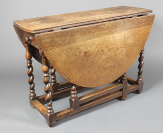 An 18th Century oak oval drop flap dining table fitted a drawer, raised on spiral turned supports 28"h x 40 1/2" w x 51" l