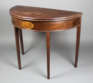 A Georgian mahogany demi-lune card table with inlaid panelled apron raised on square tapering supports 30"h x 36"w x 171/2"d when closed