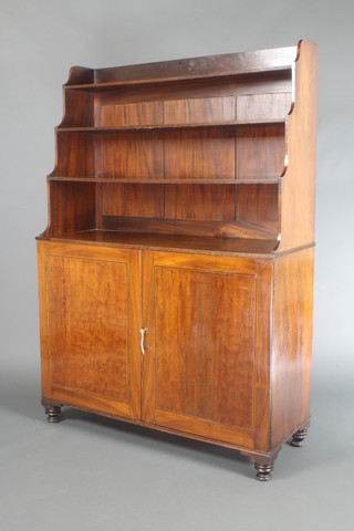 A Georgian inlaid mahogany waterfall bookcase on cabinet, the upper section with three-quarter gallery and fitted 4 shelves, the base fitted a cupboard enclosed by panelled doors, inlaid ebony and satinwood stringing, raised on bun feet 62"h x 43 1/2"w x 16"d 