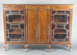 An Edwardian Chippendale style mahogany breakfront bookcase cabinet, the centre section fitted a cupboard enclosed by panelled doors flanked by a pair of cabinets, the interiors fitted adjustable shelves enclosed by astragal glazed panelled doors, raised on carved cabriole, claw and ball supports 49"h x 72"w x 16 1/2"d 
