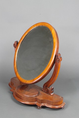 A Victorian oval plate dressing table mirror contained in a mahogany swing frame, the base of serpentine outline, fitted a jewellery box with hinged lid, raised on bun feet 25"h x 24"w x 10"d 