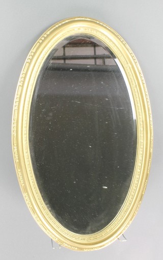 An oval bevelled plate wall mirror contained in a decorative gilt frame 30" x 19"