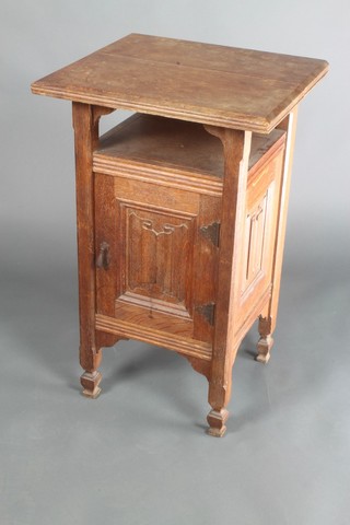 An Art Nouveau square oak bedside cabinet fitted a recess above a linen fold panelled door, raised on square supports 30"h x 19"w 