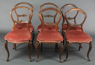 A harlequin set of 6 Victorian carved walnut balloon back dining chairs with carved pierced mid rails, the seats of serpentine outline raised on cabriole supports  