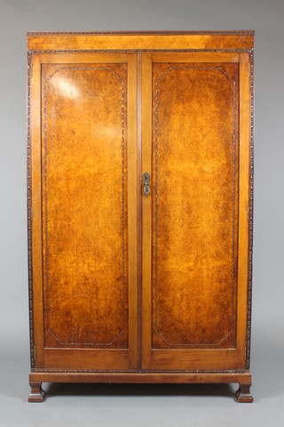 Waring & Gillow, A 1930's Art Deco Queen Anne style figured walnut wardrobe with moulded cornice enclosed by panelled doors, raised on square feet 70"h x 42"w x 19"d 
