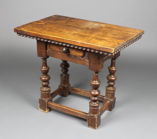 A 17th Century style walnut apprentice style table with carved and shaped apron, fitted a drawer and raised on turned and block supports 19"h x 23"w x 15 1/2"d 