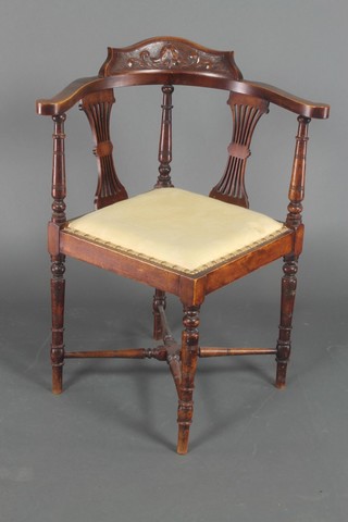 A Victorian carved walnut corner chair with pierced splat back, raised on turned supports with X frame stretcher