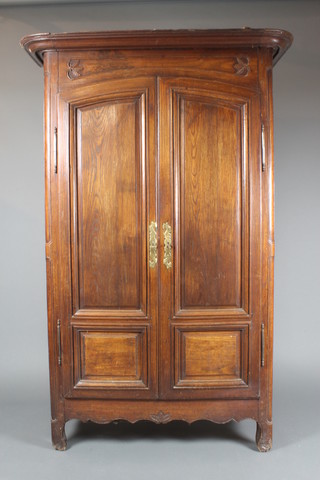 A French 18th Century carved and panelled oak armoire with moulded cornice, the interior fitted shelves enclosed by arched panelled doors 72"h x 48"w x 21"d  