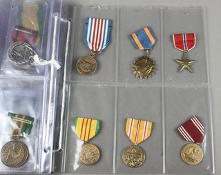 A folder of 58 19th Century and later Continental and world medals and badges