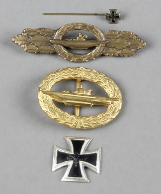 A German oval U-Boat badge, a U-Boat Close Combat clasp and a miniature first class Iron Cross pin, all of 1957 manufacture