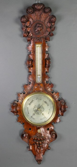 A Victorian mercury wheel barometer and thermometer with silvered dial contained in a heavily carved oak case with portrait bust of a gentleman 