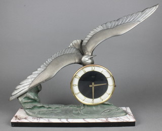 An Art Deco timepiece with Arabic numerals contained in a spelter and 2 colour marble case, surmounted by a figure of a bird 