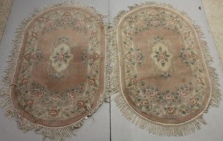 A pair of Chinese peach ground and floral patterned rugs 62 1/2" x 37" 