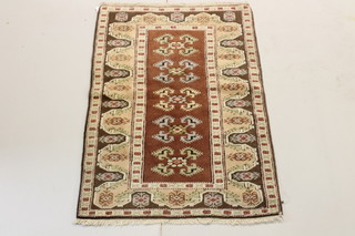 A brown and white ground Turkish caucasian style rug with stylised gulls to the centre 57" x 36" 