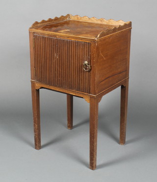 A Georgian style mahogany bedside cabinet with wavy three-quarter gallery enclosed by reeded panelled door, raised on square tapering supports 27"h x 15"w x 13"d 