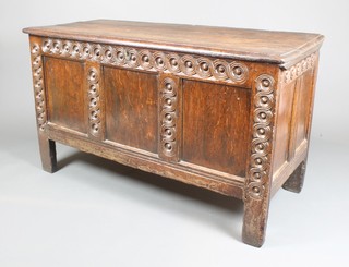 A 17th/18th Century carved oak coffer of panelled construction with 3 plankt top, the interior fitted a candle box with carved roundels to the front 32"h x 55"w x 24"d 