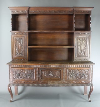 A Victorian carved oak dresser, the raised back with moulded cornice, fitted 3 shelves flanked by a pair of cupboards and enclosed by panelled doors carved game, above cupboard and 2 long drawers, raised on cabriole supports 81"h x 71"w x 17 1/2"d 
