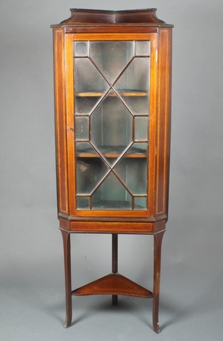 An Edwardian inlaid mahogany corner cabinet with raised back, fitted shelves enclosed by an astragal glazed panelled door, the base fitted an undertier, raised on outswept supports 60"h x 21"w x 13"d 
