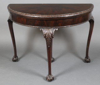 An Edwardian Chippendale style mahogany demi-lune card table, raised on cabriole ball and claw supports 29 1/2"h x 39"w x 19 1/2"d 