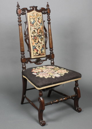 A Victorian rosewood nursing chair, the seat and back upholstered in Berlin woolwork  