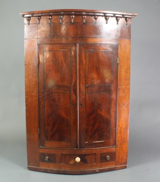 A Georgian mahogany hanging corner cabinet with moulded and shaped cornice, the interior fitted shelves above 1 long drawer 49"h x 34"w x 19 1/2"d 