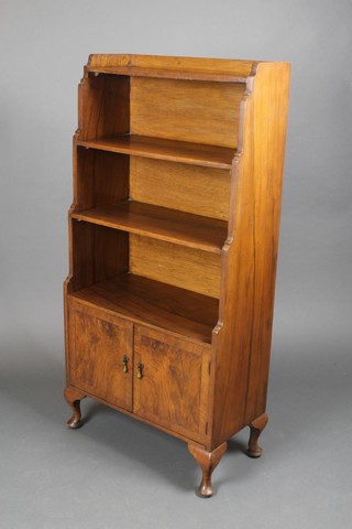 An Art Deco Georgian style walnut 4 tier waterfall bookcase, the base fitted a double cupboard, raised on cabriole supports 48"h x 23 1/2"w x 11 1/2"d 