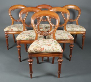 A set of 6 Victorian mahogany balloon back dining chairs with shaped mid rails and upholstered seats, raised on turned supports 