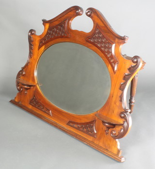 An Edwardian oval bevelled plate mirror contained in a carved walnut over mantel frame 33"h x 45"w