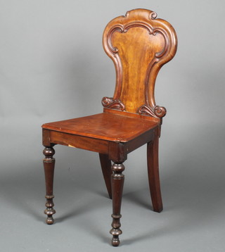 A Victorian mahogany hall chair with shaped back and solid seat, raised on turned supports 