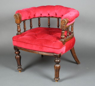 A William IV mahogany tub back armchair with bobbin turned decoration, the seat upholstered in red buttoned material on turned and reeded supports, 