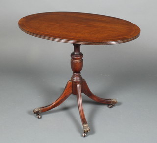A Georgian style oval mahogany wine table with crossbanded top raised on pillar and tripod supports 21"h x 26"w x 17 1/2"d 