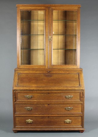 An Edwardian Art Nouveau oak bureau bookcase, the upper section with moulded cornice, the shelved interior enclosed by bevelled glazed panelled doors, the fall front revealing a fitted interior above 3 long graduated drawers with brass drop handles 76 1/2"h x 43 1/2"w x 18 1/2"d 
